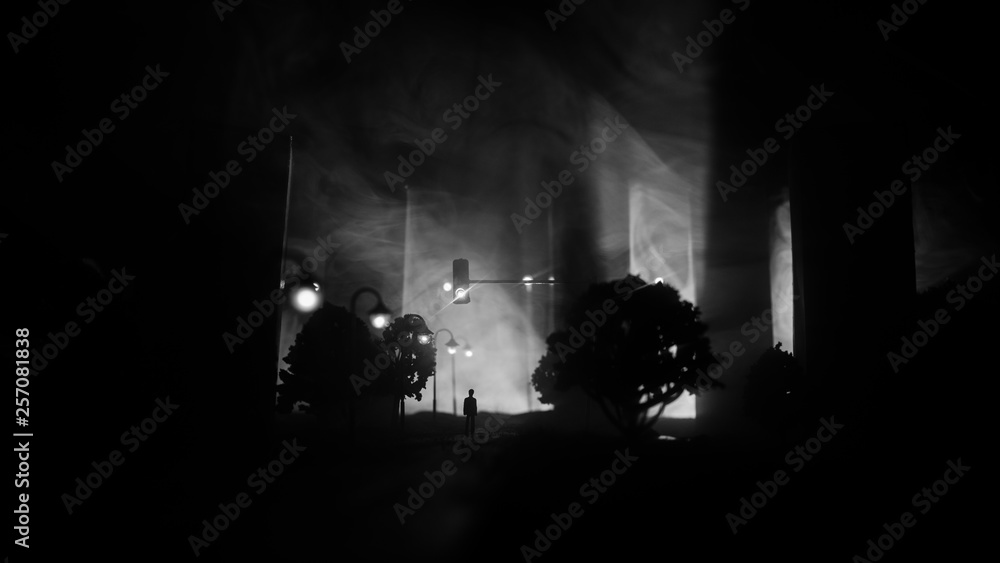 Obraz premium Artwork decoration. A man standing on a road of burnt up city. Apocalyptic view of city downtown as disaster film poster concept. Night scene. City destroyed by war.