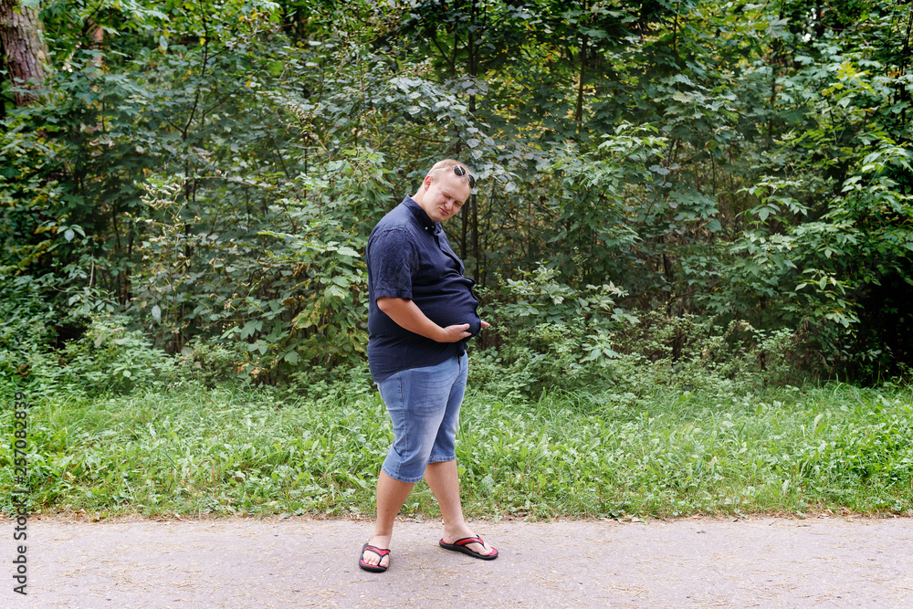 portrait of a fat guy in summer against a park portrait of a fat guy in summer against a park