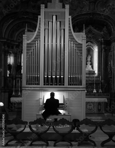 Фотография Man playing pipe organ in a church