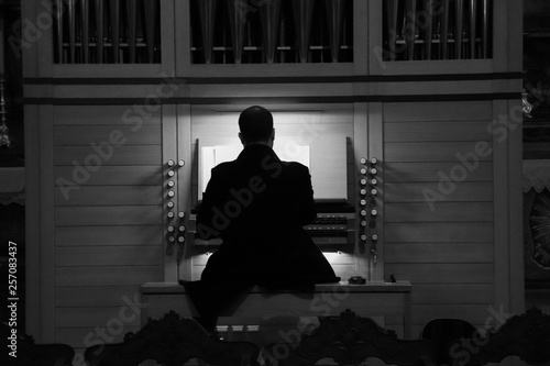 Фотография Man playing pipe organ in a church
