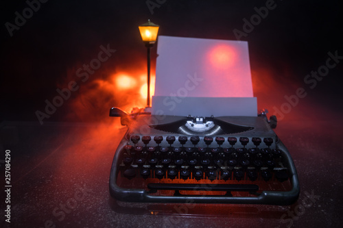 Old fashion typewritter on dark foggy background. Close up of vintage typewritter machine photo