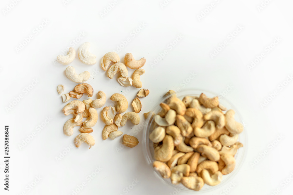 Healthy food for background image close up cashew nuts. Nuts texture on white grey table top view on the cup plate Healthy food for background image close up cashew nuts. Nuts texture on white grey table top view on the cup plate