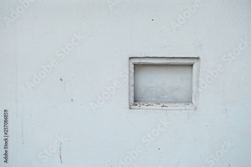 A grid block on old white wall in outdoor area with copy space 