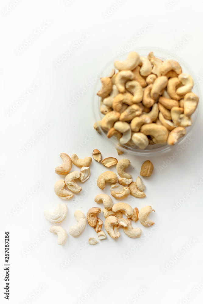Healthy food for background image close up cashew nuts. Nuts texture on white grey table top view on the cup plate Healthy food for background image close up cashew nuts. Nuts texture on white grey table top view on the cup plate