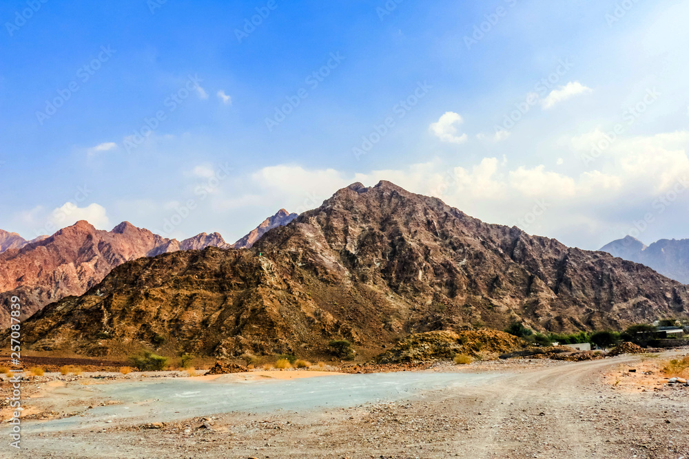 Geological landscape of Jabal Jais characterised by dry and rocky mountains, Road between mud mountains in Ras Al Khaimah, United Arab Emirates