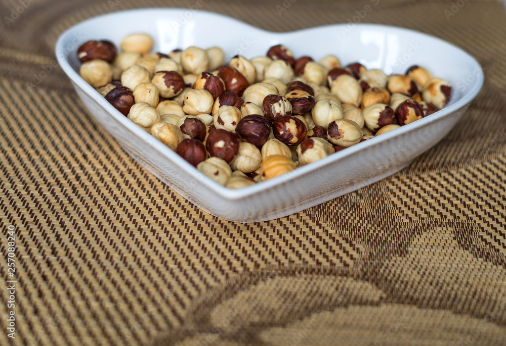 Nuts arranged in heart on background. Healthy Food image close up hazelnuts. Love Texture on top view Nuts arranged in heart on background. Healthy Food image close up hazelnuts. Love Texture on top view