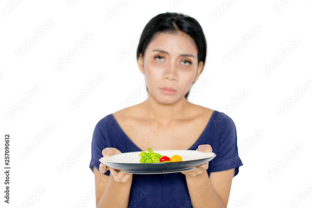 Pale woman holds small portion salad on studio Pale woman holds small portion salad on studio
