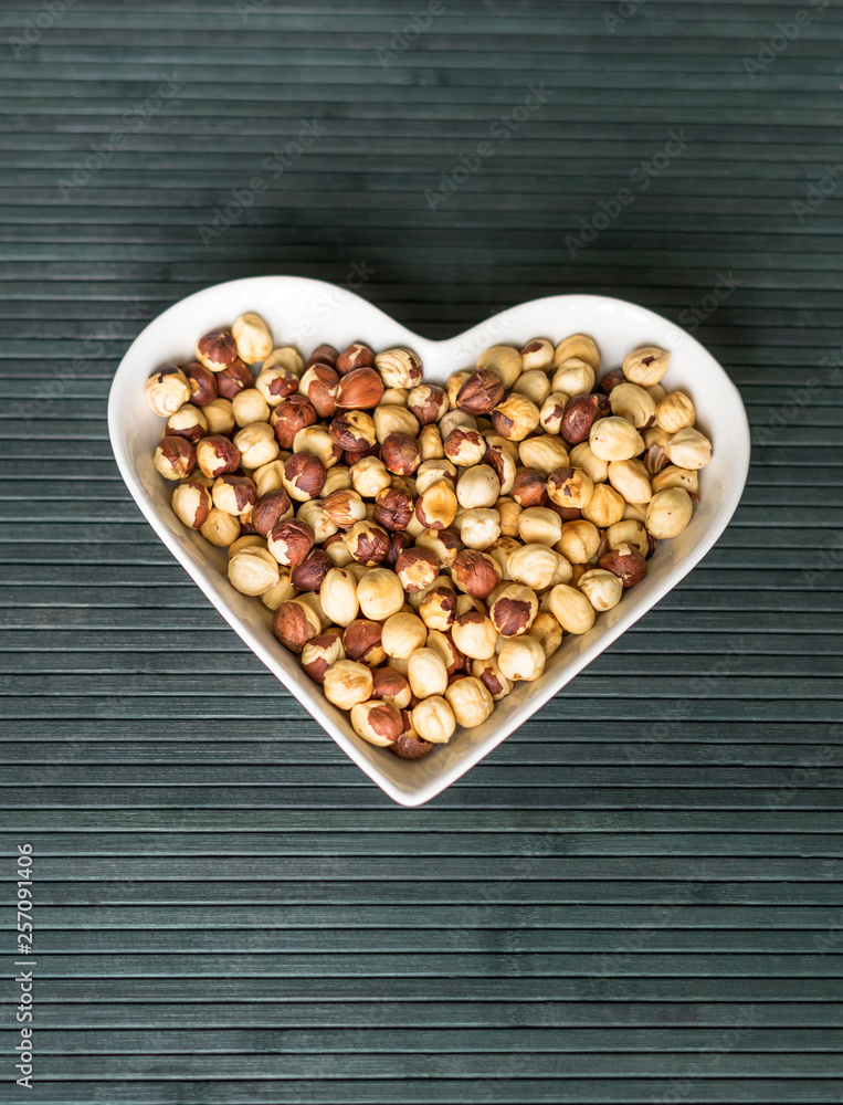 Nuts arranged in heart on background. Healthy Food image close up hazelnuts. Love Texture on top view Nuts arranged in heart on background. Healthy Food image close up hazelnuts. Love Texture on top view