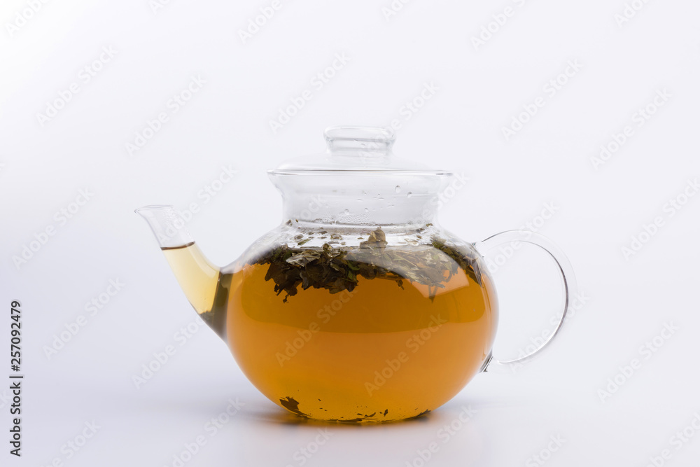 Glass teapot with herbal tea isolated on white background