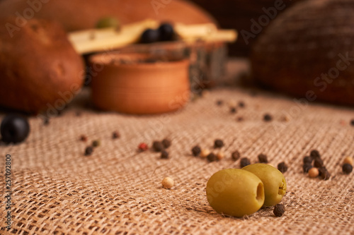 olive is on the table in background of bread, baguette and cheese. Selective focus