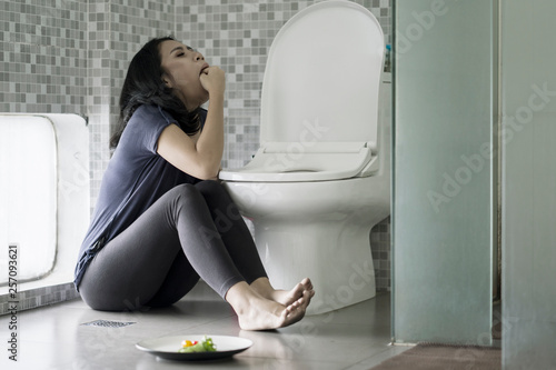 Woman forcing herself to vomit on bathroom