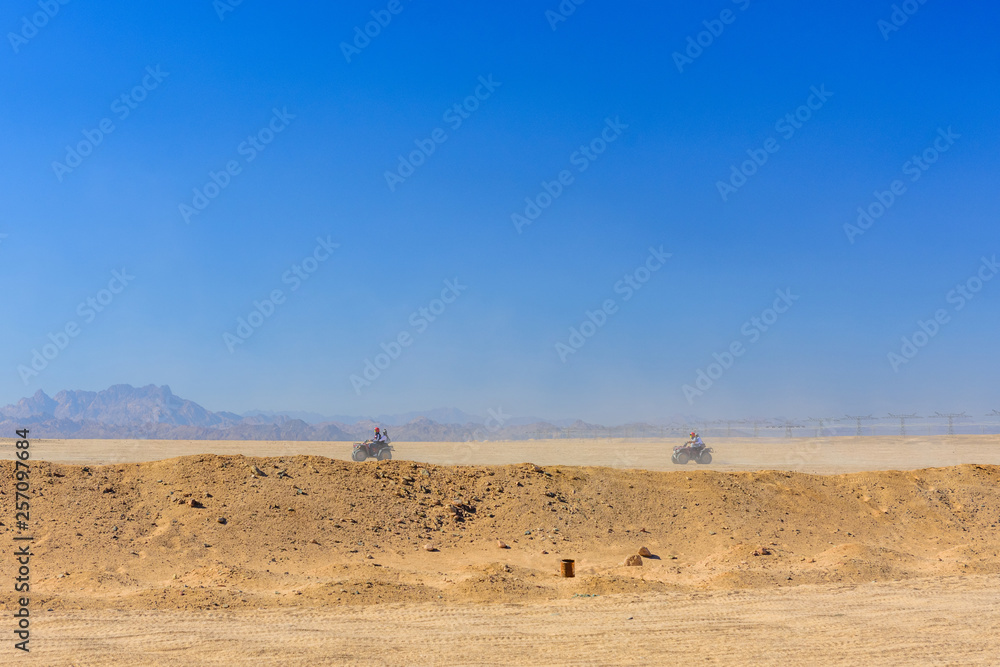 People driving quad bikes during safari trip in Arabian desert not far from the Hurghada city, Egypt