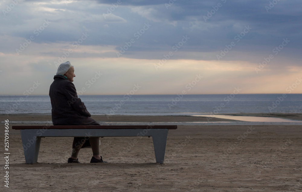 old lonely retired grandmother sitting on a bench