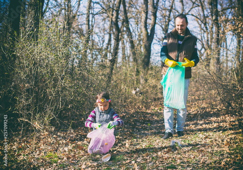 father and daughter gathering garbage in the park