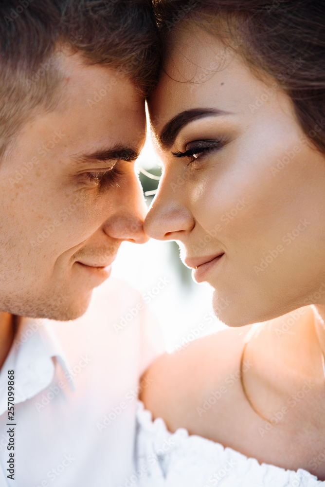 Close-up photo of young loving couple. Guy gently hugs his beautiful girlfriend Close-up photo of young loving couple. Guy gently hugs his beautiful girlfriend