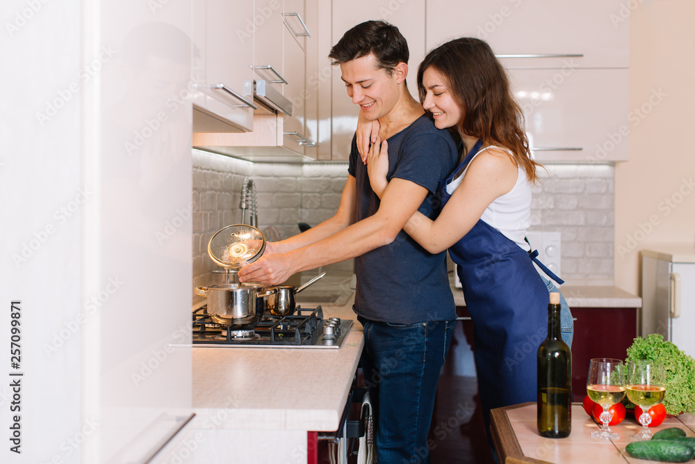 Couple cooking together in the kitchen at home Couple cooking together in the kitchen at home