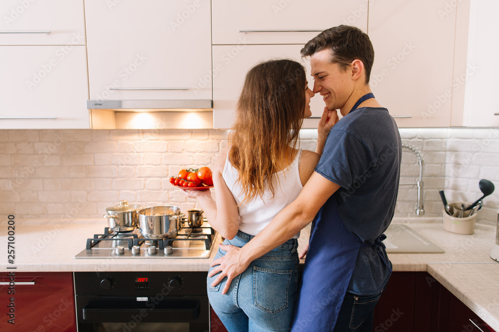 Couple cooking together in the kitchen at home Couple cooking together in the kitchen at home