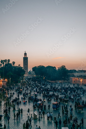 Obraz na plátne A beautiful view of the famous minaret as well as the bustling activity in the streets of Marrakech at dusk