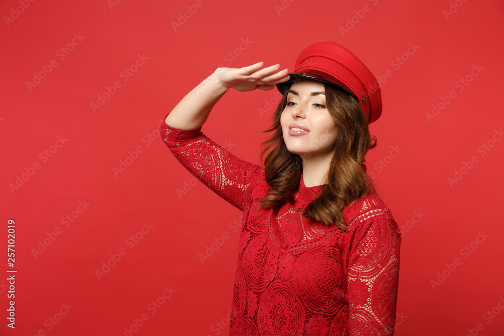 Attractive young woman in lace dress, cap holding hand at forehead looking far away†distance isolated on bright red background in studio. People sincere emotions lifestyle concept. Mock up copy space. Attractive young woman in lace dress, cap holding hand at forehead looking far away†distance isolated on bright red background in studio. People sincere emotions lifestyle concept. Mock up copy space.