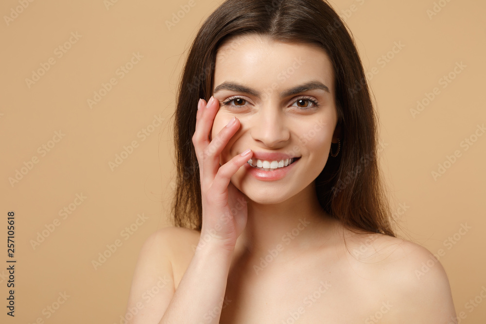 Close up brunette half naked woman 20s with perfect skin, nude make up isolated on beige pastel wall background, studio portrait. Skin care healthcare cosmetic procedures concept. Mock up copy space. Close up brunette half naked woman 20s with perfect skin, nude make up isolated on beige pastel wall background, studio portrait. Skin care healthcare cosmetic procedures concept. Mock up copy space.