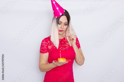 Blond in party hat holding cake