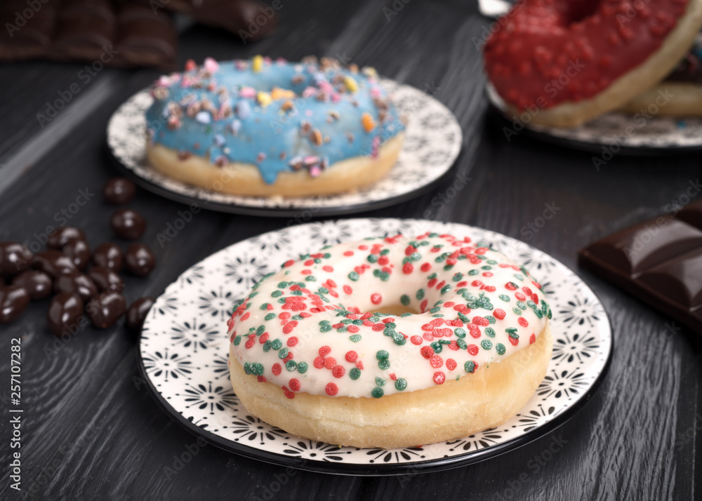 colorful glazed donuts on black wooden table