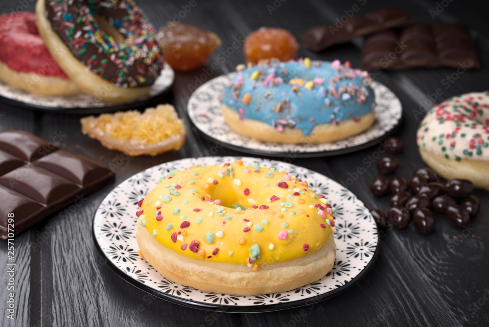 colorful glazed donuts on black wooden table