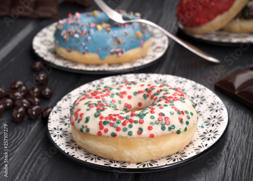 colorful glazed donuts on black wooden table