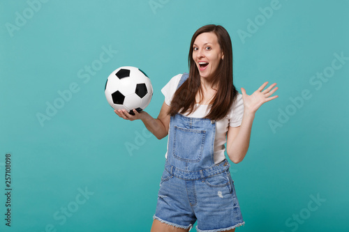 Excited young woman football fan cheer up support favorite team with soccer ball isolated on blue turquoise wall background. People emotions sport family leisure lifestyle concept. Mock up copy space. © ViDi Studio