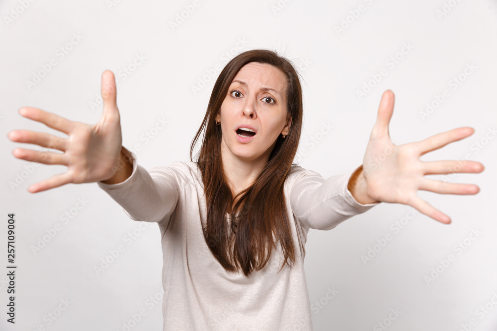 Portrait of puzzled displeased young woman in light clothes standing with outstretched hands isolated on white wall background in studio. People sincere emotions lifestyle concept. Mock up copy space. Portrait of puzzled displeased young woman in light clothes standing with outstretched hands isolated on white wall background in studio. People sincere emotions lifestyle concept. Mock up copy space.