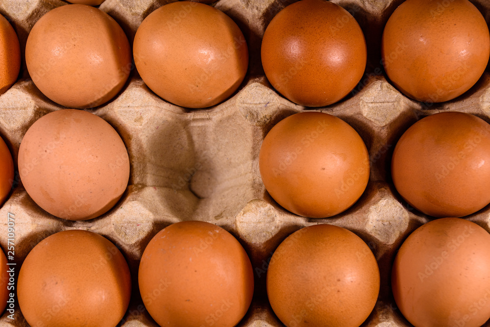 Pile of the hen eggs in paper tray on wooden table. Top view Pile of the hen eggs in paper tray on wooden table. Top view
