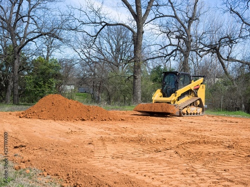 Skid Steer Loader Lifting Dirt from Pile
