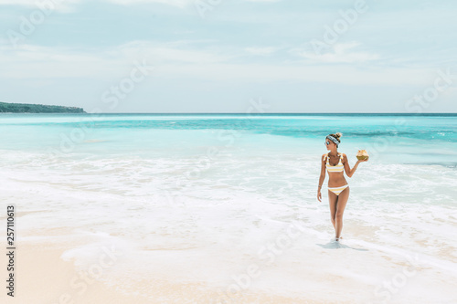 Woman drinking coconut on the tropical beach
