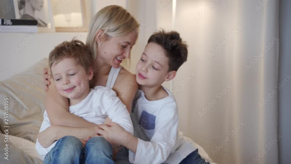 Happy family - mother with two sons hugging in bed Happy family - mother with two sons hugging in bed
