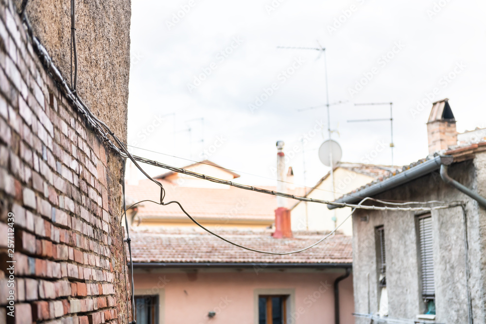 Chiusi, Italy small historic medieval town village in Umbria near Tuscany closeup view of roof apartment buildings during summer day with power lines Chiusi, Italy small historic medieval town village in Umbria near Tuscany closeup view of roof apartment buildings during summer day with power lines