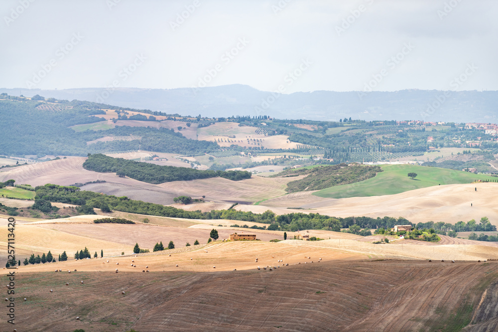 Obraz premium Countryside in Val D'Orcia Tuscany, Italy with aerial bales rolling plowed brown hills and villas with farm landscape meadow fields high angle
