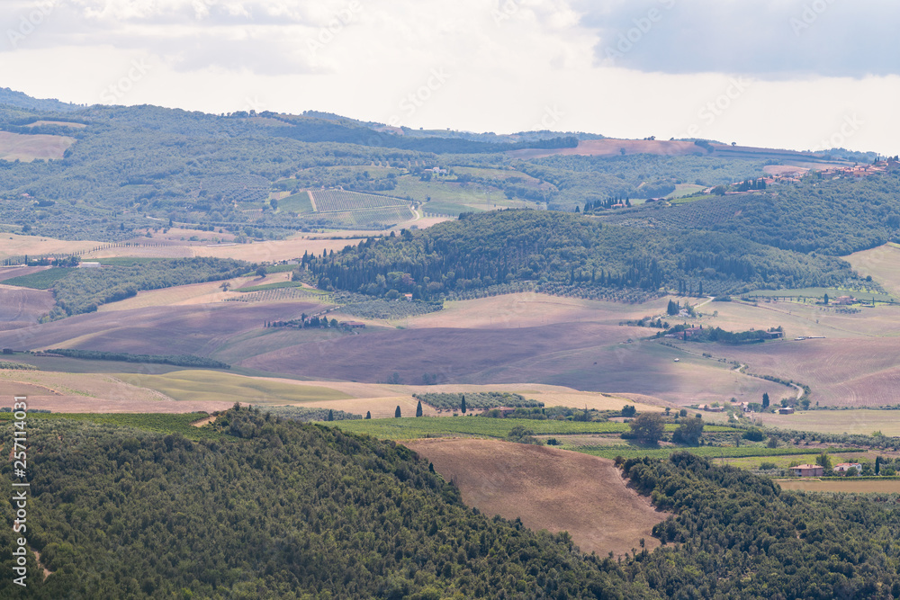 Val D'Orcia countryside aerial high angle view in Tuscany, Italy with rolling plowed brown hills with farm landscape picturesque meadow fields