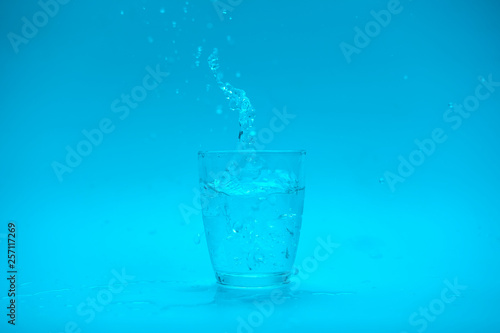 Glass of water with splash isolated on white background