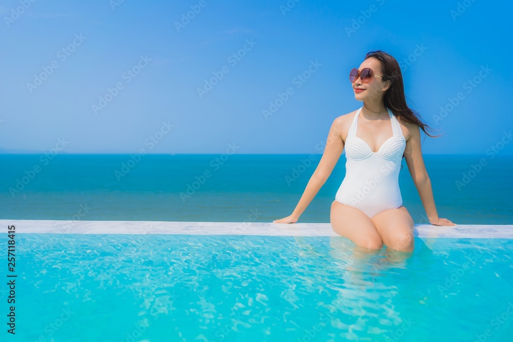 Portrait beautiful young asian woman happy smile relax in swimming pool for travel vacation