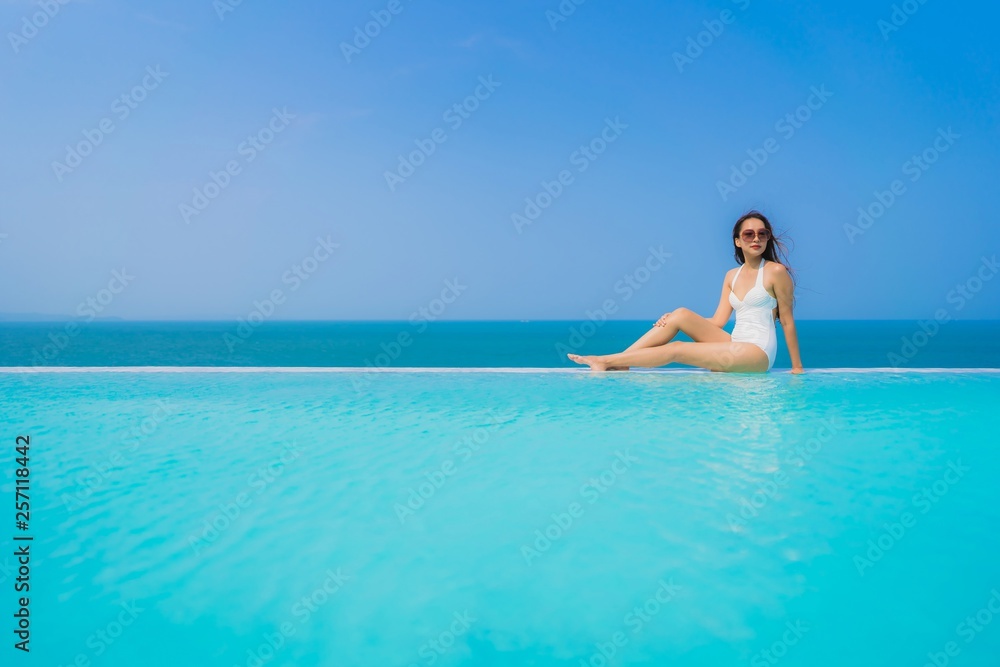 Portrait beautiful young asian woman happy smile relax in swimming pool for travel vacation