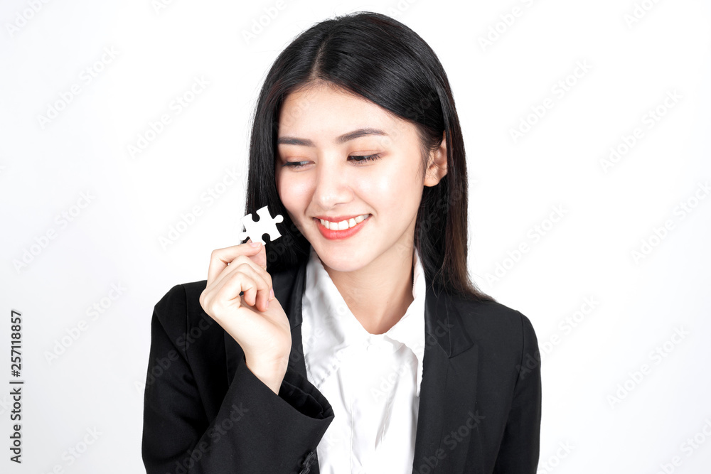 business woman holding and showing a jigsaw puzzle - business concept business woman holding and showing a jigsaw puzzle - business concept