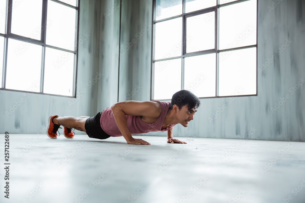 asian sportsman doing push up at the fitness centre asian sportsman doing push up at the fitness centre