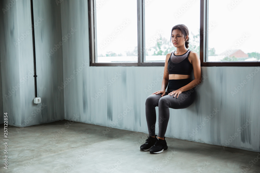 asian sportswoman doing workout for endurance power legs beside a windows asian sportswoman doing workout for endurance power legs beside a windows