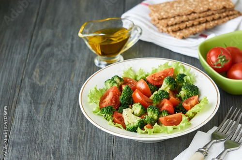 Salad with broccoli and cherry tomatoes in a white bowl
