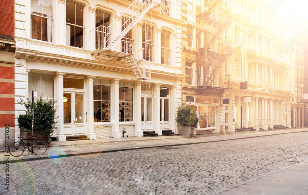 Sunlight shines on the empty sidewalks along cobblestone covered Greene Street in the SoHo neighborhood of Manhattan in New York City