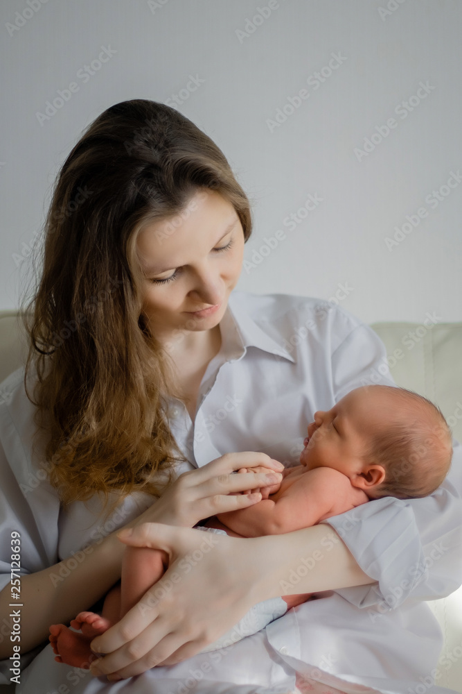 Pretty woman holding a newborn baby in her arms Pretty woman holding a newborn baby in her arms
