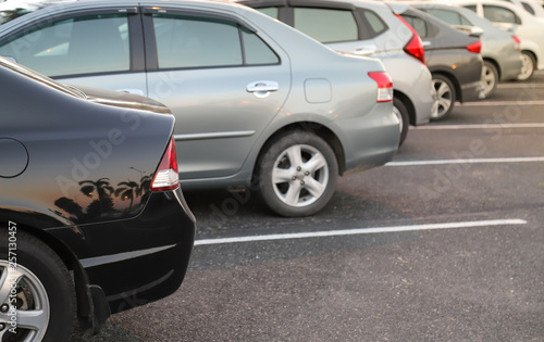 Closeup of rear or back side of black car with  other cars parking in outdoor parking area in twilight evening.  © Amphon
