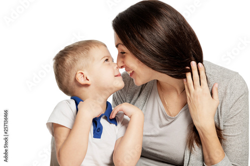 Cute little boy laughs and hugs with mom, isolated on white background. Tenderness and love.