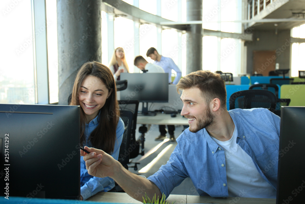 Young modern colleagues in smart casual wear working while spending time in the office.