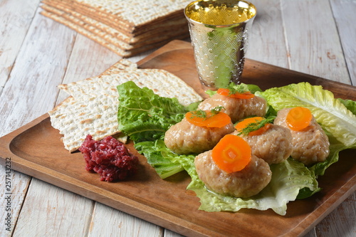 Passover Pesach traditional Jewish food - gefilte fish with, lettuce, carrots, horse radish and matzah. Passover celebration concept photo